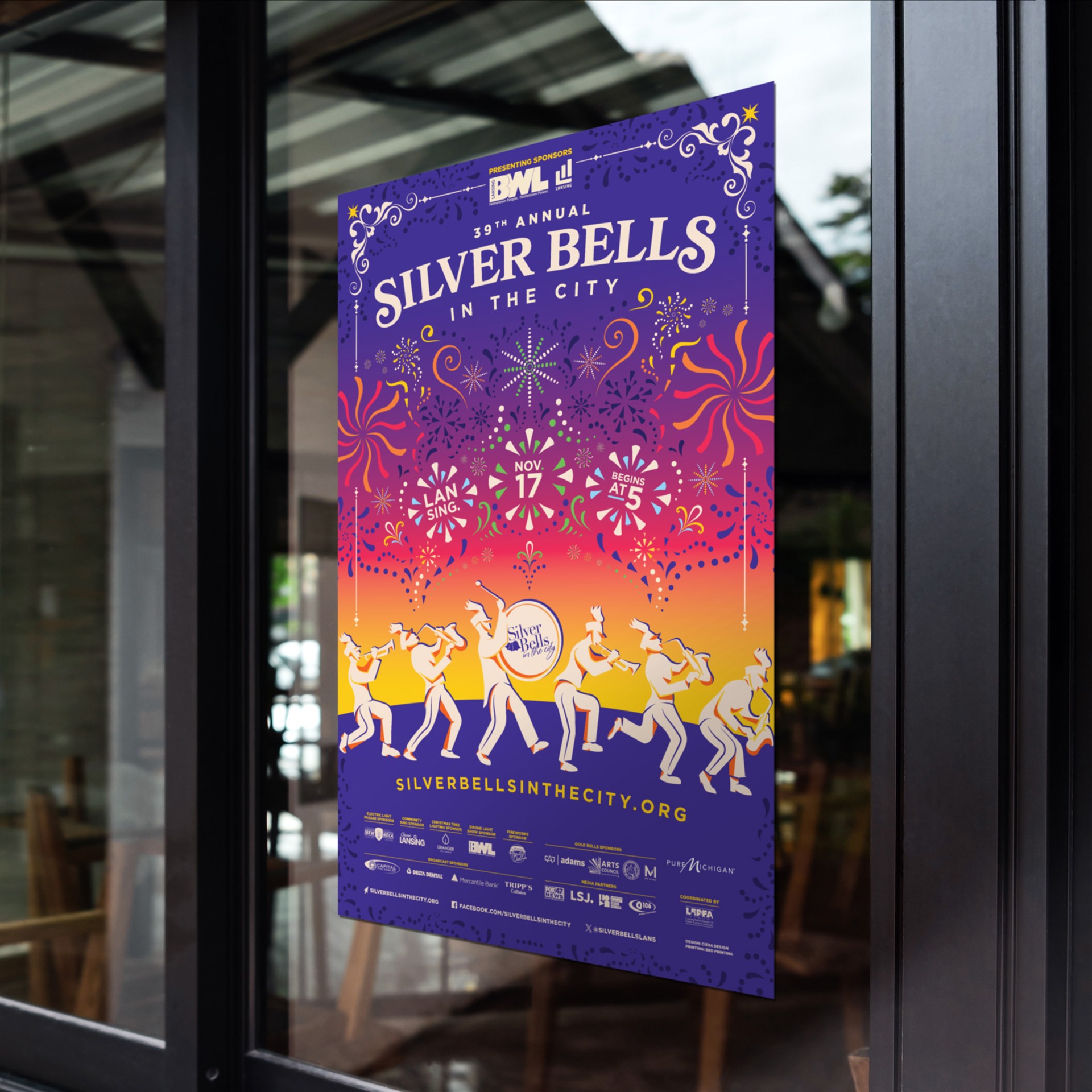 Silver Bells in the City 2023 poster hanging on a glass window.